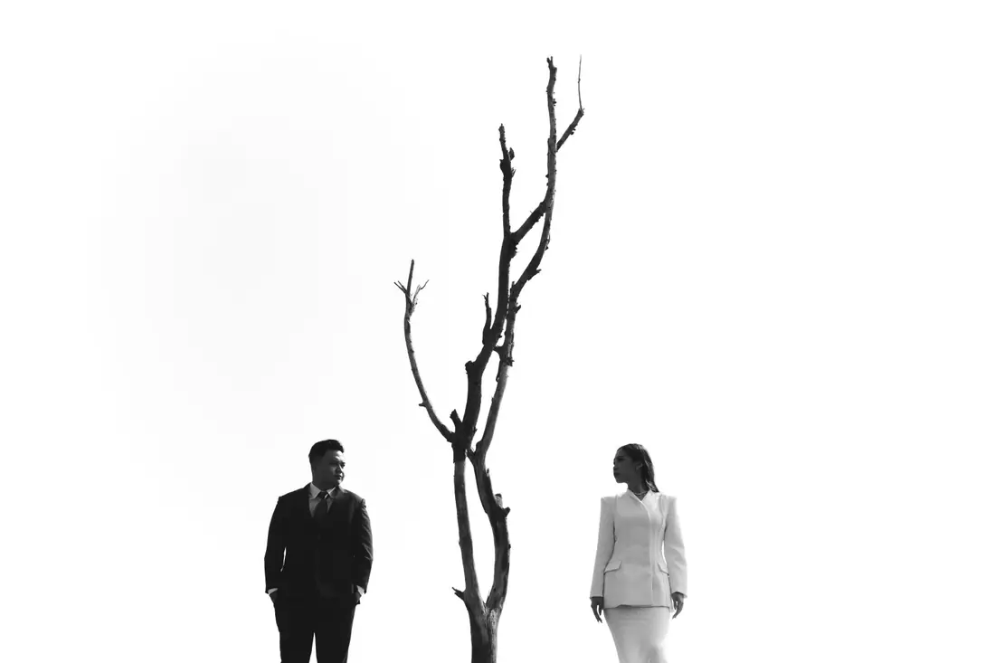 Irfan and Stephanie on either side of a bare tree, black and white