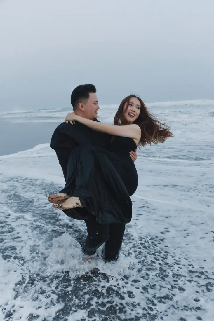 Irfan carrying a laughing Stephanie through the waves