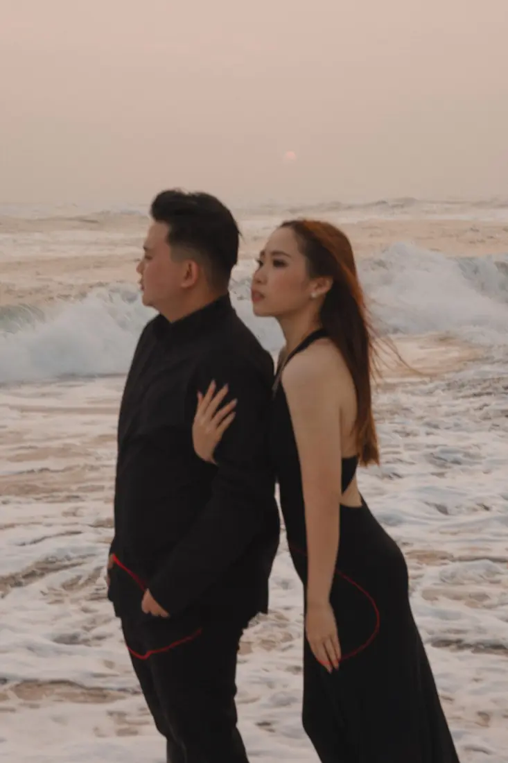 Irfan and Stephanie standing against the waves at sunset
