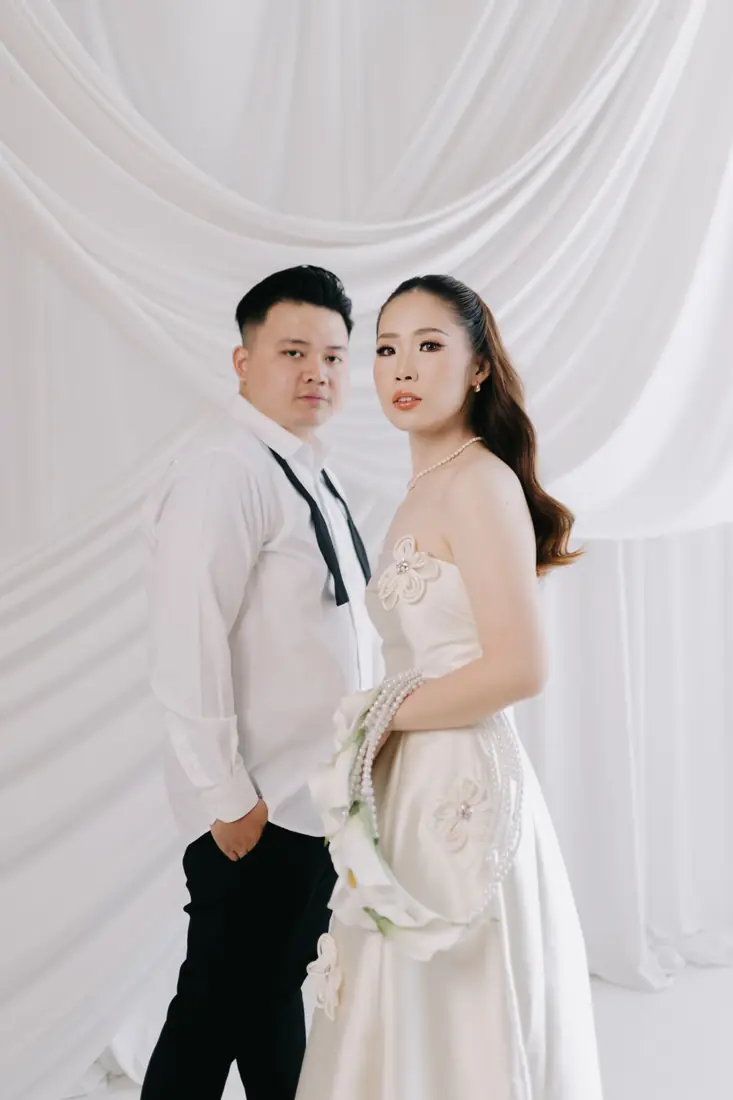 Irfan and Stephanie posing in front of white drapes